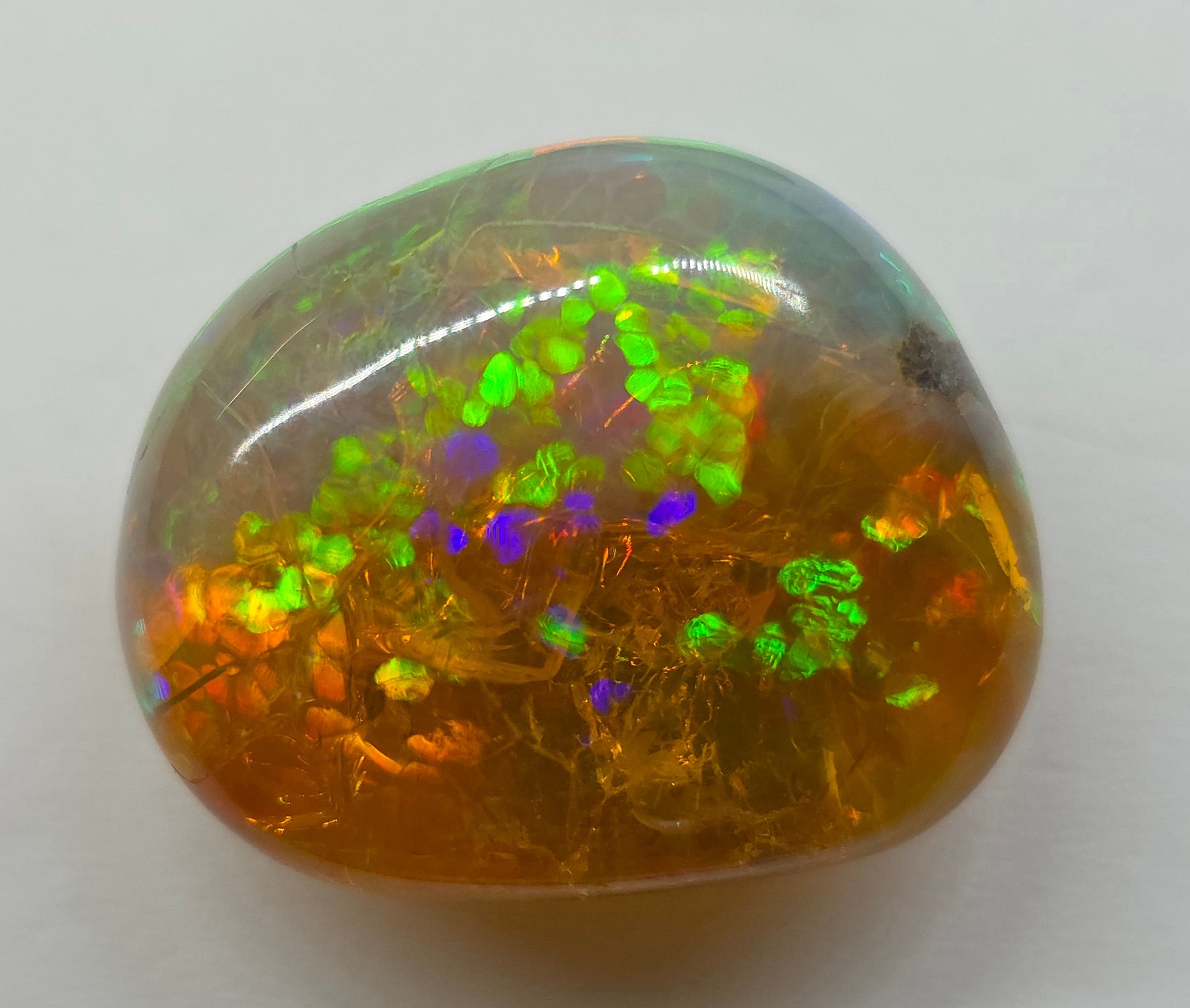 Multicolored opal stone on a white background
